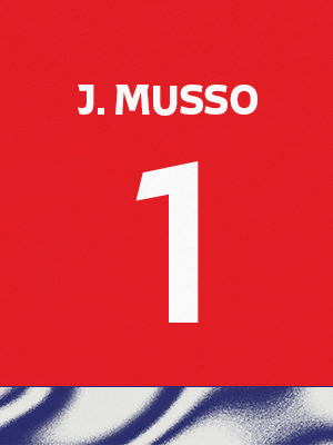 Dorsal de color rojo con el nombre 'J. Musso' y el número 1 en blanco, sobre un borde inferior con patrón ondulado azul y blanco.